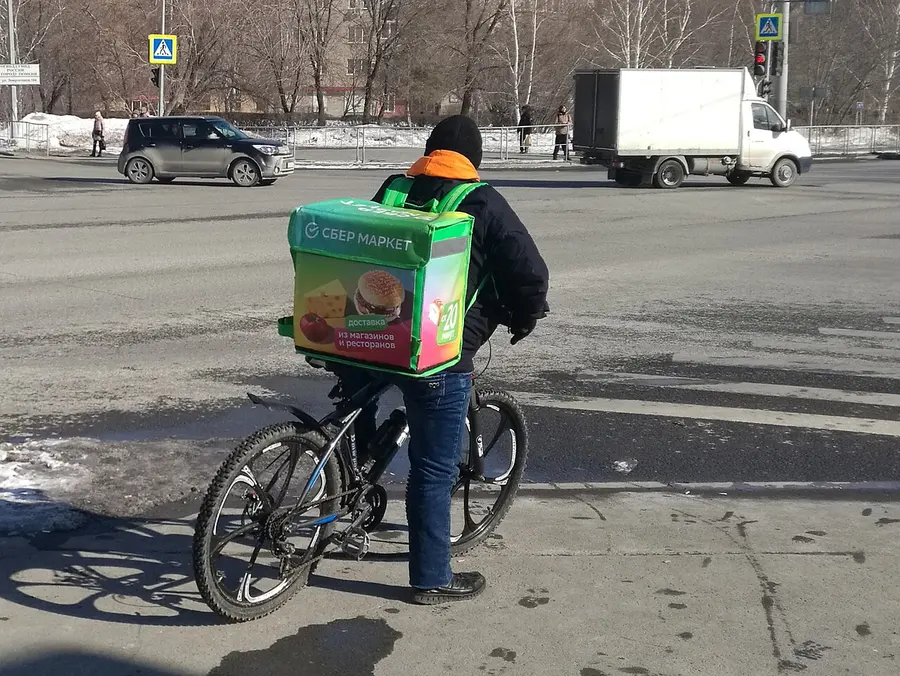 Велокурьер с термосумкой на улице